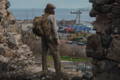 Man wearing an Isle Royale pack on a hill overlooking downtown Duluth with the lift bridge in the background.