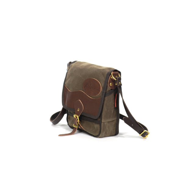 Waxed canvas and leather flap closure with a riveted leather strap and solid brass buckle.